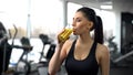 Fit woman drinking refreshing juice from glass after gym workout, health care