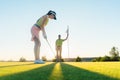 Fit woman exercising hitting technique during golf class Royalty Free Stock Photo