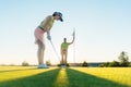 Fit woman exercising hitting technique during golf class with an