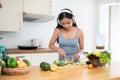 A fit woman in gym clothes and headphones is preparing her healthy breakfast in the kitchen Royalty Free Stock Photo