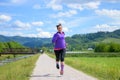 Fit woman jogging along a rural lane