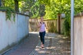 Fit woman jogging down a leafy shady lane