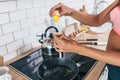 Fit woman in kitchen cracking egg into frying pan. Royalty Free Stock Photo