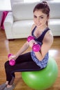 Fit woman lifting dumbbells on exercise ball Royalty Free Stock Photo