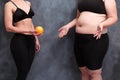 Fit woman offering grapefruit to overweight lady. Extreme diet,