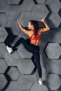 Fit woman posing like a climber hanging on decorative wall Royalty Free Stock Photo