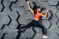 Fit woman posing like a climber hanging on decorative wall Royalty Free Stock Photo