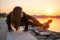 Fit woman practicing yoga, doing arm stand Astavakrasana, asymmetrical arm balance EightAngle Pose near the sea coast. Royalty Free Stock Photo