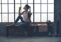 Fit woman in profile sitting on bench in loft gym drinking water Royalty Free Stock Photo