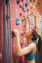 Fit woman rock climbing indoors Royalty Free Stock Photo