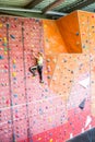 Fit woman rock climbing indoors Royalty Free Stock Photo