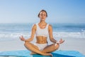 Fit woman sitting in lotus pose on the beach Royalty Free Stock Photo