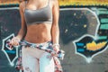 Fit woman in sport bra and jeans outdoors at the park. Very fit body with strong abs Royalty Free Stock Photo