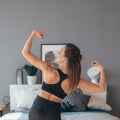 Fit woman in sportswear showing her muscles. Back view.