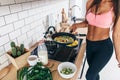 Fit woman standing at kitchen preparing healthy breakfast Royalty Free Stock Photo