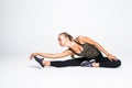 Fit sport woman stretching her leg to warm up isolated over white background Royalty Free Stock Photo