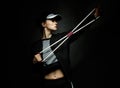 Fit woman training with resistance band against black background Royalty Free Stock Photo