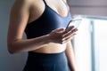 Fit woman using phone. Gym workout and exercise with sport tracker mobile app in smartphone. Athlete, fitness model, health expert Royalty Free Stock Photo