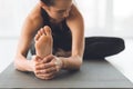 Fit woman warmup stretching, training indoors, focus on foot