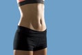 Fit woman wearing shorts and sport top showing slim beautiful stomach and abs Royalty Free Stock Photo