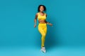 Fit woman in yellow sportswear measuring waist with tape Royalty Free Stock Photo