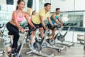 Fit women burning calories during indoor cycling class in a fitness club Royalty Free Stock Photo