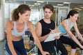 Fit women in a spin class with trainer taking notes Royalty Free Stock Photo