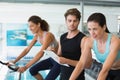 Fit women in a spin class with trainer taking notes Royalty Free Stock Photo