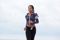 Fit young african american woman running outdoors Royalty Free Stock Photo