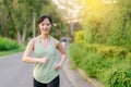 Fit Asian young woman jogging in park smiling happy running and enjoying a healthy outdoor lifestyle. Female jogger. Fitness Royalty Free Stock Photo