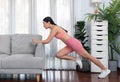 Fit young asian woman stretching her leg her body using sofa. Vigorous Royalty Free Stock Photo