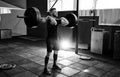 Fit young athlete lifting the barbell in gym. Gym training.