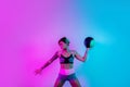 Fit young blonde woman exercise with medicine ball in gym in neon lights. Royalty Free Stock Photo