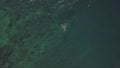 A fit young man enjoys swimming anf floating in the blue ocean at summer.