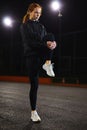 Fit young woman doing stretching workout outdoors in city street at night. Royalty Free Stock Photo