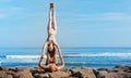 Fit young couple doing acro yoga exercise at sea beach Royalty Free Stock Photo