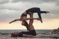 Fit young couple doing acro yoga for healthy lifestyle on tropical coast Royalty Free Stock Photo