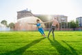 Fit young couple doing acro yoga in the park or on the field stadium. Man standing on the grass and balancing his woman on hands. Royalty Free Stock Photo