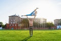 Fit young couple doing acro yoga in the park or on the field stadium. Man standing on the grass and balancing his woman on hands. Royalty Free Stock Photo