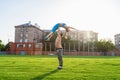 Fit young couple doing acro yoga in the park or on the field stadium. Man standing on the grass and balancing his woman on hands. Royalty Free Stock Photo