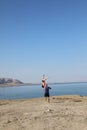 Fit young couple doing acro yoga at spa retreat on sea beach. Active woman balancing on partner feet, stretching at