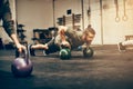 Fit young man planking with dumbbells at the gym