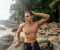 Fit young man posing shirtless on the tropical beach. Handsome guy relaxing on vacation. Summer time. Traveler. Tropical vibes Royalty Free Stock Photo