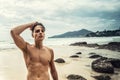 Fit young man posing shirtless on the tropical beach, looking at the camera. Handsome sexy guy. Summer time. Traveler. Tropical Royalty Free Stock Photo