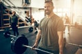 Fit young man smiling and lifting weights in a gym Royalty Free Stock Photo