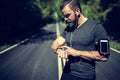 Fit young man setting his sports watch before a run Royalty Free Stock Photo
