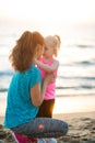 Fit young mother and daughter on beach giving Eskimo kisses Royalty Free Stock Photo