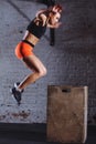 Woman box jumping at cross fit gym. athlete doing box jumps exercise at gym Royalty Free Stock Photo