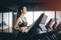 Fit young woman caucasian running on machine treadmill workout in gym. Glad smiling girl is enjoy with her training process. Royalty Free Stock Photo