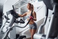 Fit young woman doing cardio on the xtrainer machine in gym. Fat burn. Health concept. Weight loss.